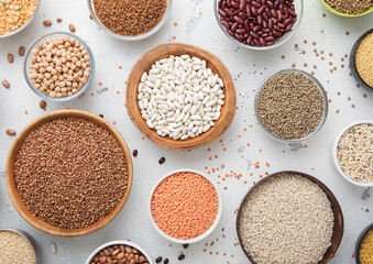 Top view of bowls with various healthy cereals. Bulgur,beans,quinoa,pea,couscous and hemp with chickpea and buckwheat seed on light kitchen background.Macro.