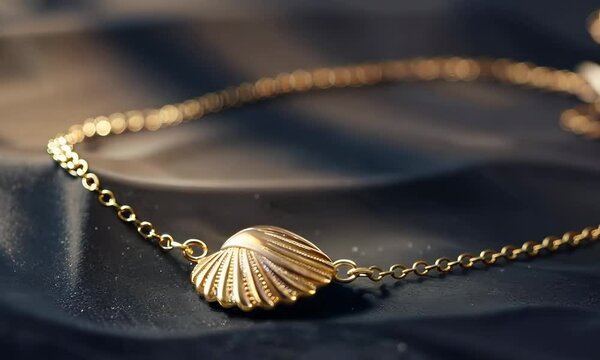 Delicate gold anklet with a charm shaped like a seashell, Video