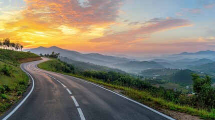 beautifully curved asphalt road stretching through a scenic landscape at sunset. The road is bordered by lush green trees and mountains
