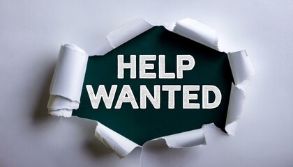The text HELP WANTED appearing behind torn white paper
