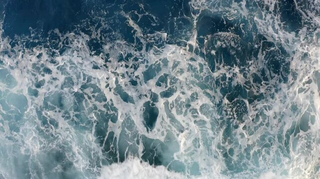 A mesmerizing top-down view of powerful ocean waves crashing and foaming against the shore, dynamic movement of the water showcases the strength and beauty of the ocean