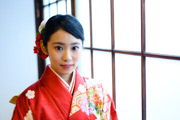 窓際にいる20代の着物を着た女性