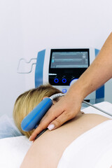 A doctor administers magnetic therapy to a young woman, targeting muscle recovery post-injury....