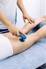 A doctor administers magnetic therapy to a young woman, targeting muscle recovery post-injury....