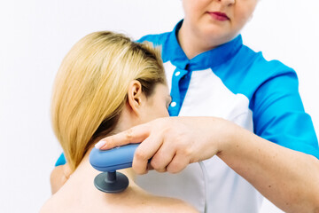 A female physiotherapist applies diathermy treatment to a patient's back, showcasing advanced techniques for pain management and muscle recovery. Ideal for illustrating expert care in physiotherapy.
