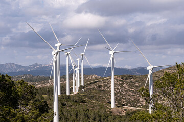 This image shows multiple wind turbines set against a dramatic cloudy sky, symbolizing the merging of nature with human ingenuity for a greener future in Tarragona Spain