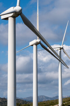 This close-up shot captures three tall wind turbines in a line, highlighting the innovative design and engineering behind modern renewable energy solutions in Tarragona Spain