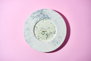 The dish features a vibrant mixture of chopped vegetables, herbs, and a protein component (possibly meat or seafood), all tossed in a cold, tangy kvass-based dressing. Okroshka