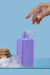 Cosmetic product in a purple jar, shower gel, face wash, shampoo or liquid hand soap stand on a glass shelf on light blue background. Moisturizing and cleansing concept. 
