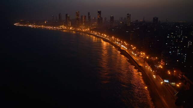 Aerial shot of Mumbai's Marine Drive, the 'Queen's Necklace' shimmering with city lights along the coastline. No people.