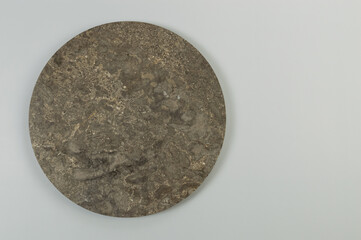 Top view of brown marble plate on grey background. Food presentation, stone tray. Copy space, flat lay.