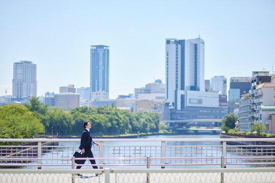 ビジネス街を歩くスーツを着た若いビジネスマンの男性