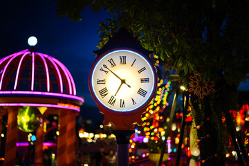 A classic design round clock with roman number with lighting decoration in colorful lighting bokeh...