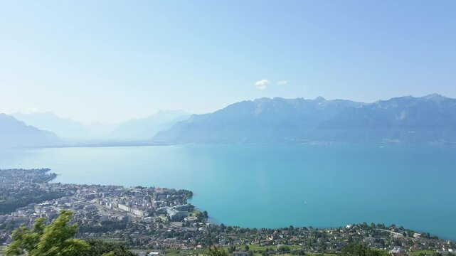 Push in with a drone above Vevey with the Lake of Geneva and the mountains behind.