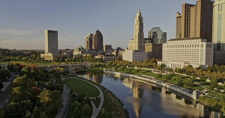 Columbus Ohio Aerial v60 flyover Scioto river capturing Discovery bridge, riverfront greenway and downtown cityscape, bathed in warm sunset glows - Shot with Mavic 3 Pro Cine - Sept 21st 2023