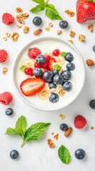 Delicious bowl of yogurt topped with fresh fruits, granola, and mint, perfect for a healthy snack or breakfast option.