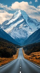 A mountain range with a road running through it. The road is empty and the mountains are covered in snow. The scene is peaceful and serene, with the mountains towering over the road