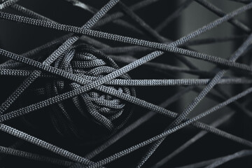 A black clew of thread as a web. Knitting art. Concept of intricacy, complexity, difficulties in...