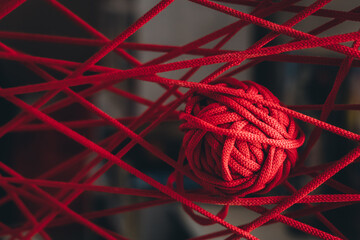 A red clew of thread as a web. Art of knitting. Concept of intricacy and complexity of life....