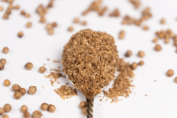 Ground coriander natural spice in a spoon close-up.