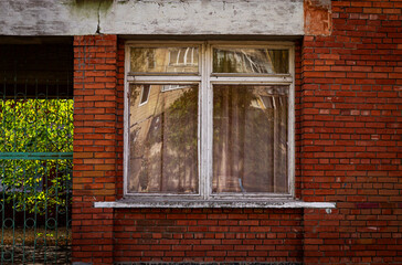 Color horizontal photo, brick red building with windows and wooden frames close up, urban background.