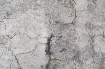 A fragment of a gray concrete wall with scratches and cracks