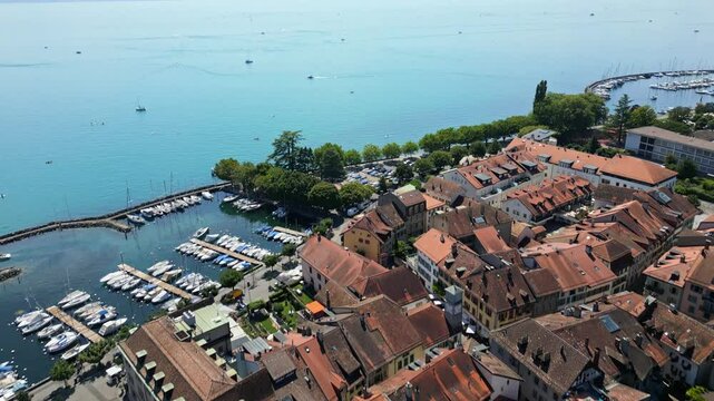 Drone reveal of the old city of Lutry with the Lake of Geneva and the Alps behind.