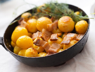 Delicious freshly cooked fried new potatoes with bacon served in a frying pan