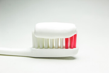 toothbrush and toothpaste on white