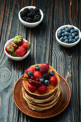 Stack of homemade american pancakes with berries . Top view