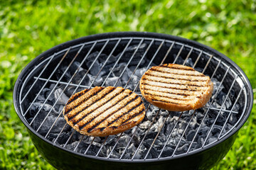 burger bread bun grilling on charcoal grill