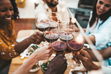 People toasting red wine glasses on rooftop dinner party - Happy friends eating meat and drinking wineglass at restaurant patio - Food and beverage lifestyle concept with guys and girls dining outdoor