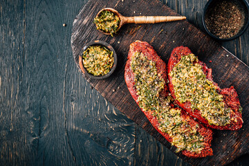 Two raw beef  steaks, marinated with herbs and spices