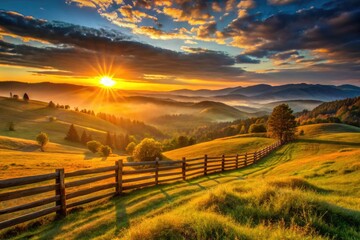 Obraz premium dramatic sunrise casts warm orange glow on vast valley landscape with rolling hills and rustic wooden fences under clear blue skies