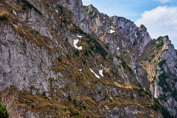 Rugged mountain slope with rocky cliffs and patches of snow. Tatra National Park in Poland. Natural landscape