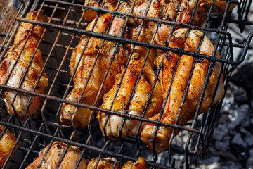 Chicken drumsticks are cooked on the grill