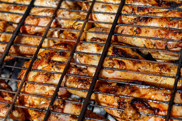 Chicken drumsticks are cooked on the grill