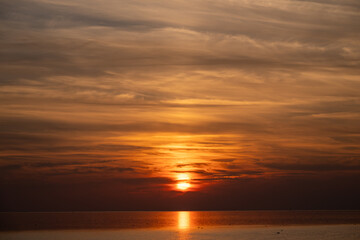 Die Nordsee bei Büsum - dramatisch schöner Sonnenuntergang mit Spiegelung auf dem Wasser und dem Watt