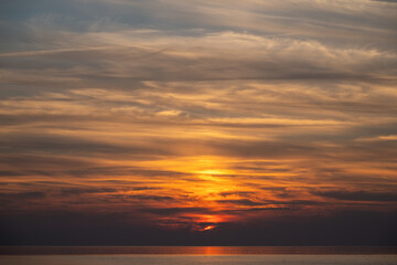 Obraz premium Die Nordsee bei Büsum - dramatisch schöner Sonnenuntergang mit Spiegelung auf dem Wasser und dem Watt