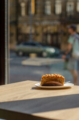 A piece of cake on a table in a cafe on the background of a window in the city center