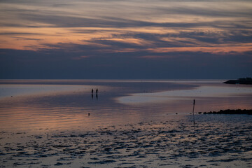 Die Nordsee bei Büsum - dramatisch schöner Sonnenuntergang mit Spiegelung auf dem Wasser und dem...