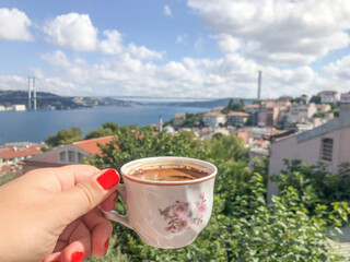 Obraz premium hand holds cup of turkish coffee against sea view in Istanbul, Turkey