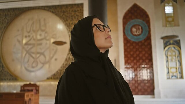 A contemplative woman in a hijab admires islamic architecture inside a qatar mosque, embodying religious, cultural, and feminine beauty.