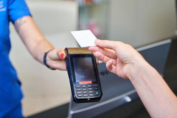 A woman is paying for something with a credit card at a store