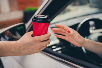 Cropped photo of lady driver hands arms riding car buying coffee to go outdoors urban city street