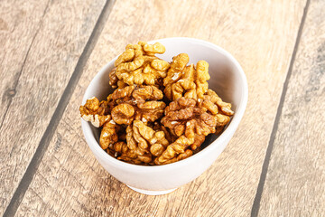 Cracked unshelled walnut in the bowl
