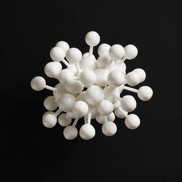a ball and stick model of one zwitterionic form of creatine, made of white clay. Floating against a completely black background.