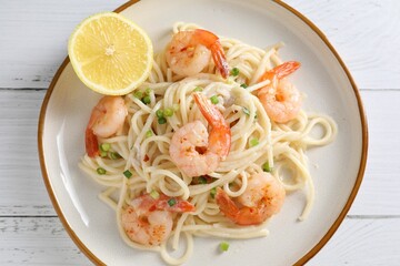 Delicious pasta with shrimps and green onion on white wooden table, top view