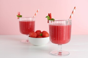 Tasty watermelon drink in glasses and fresh fruit on white wooden table