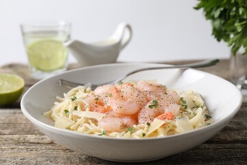 Delicious pasta with shrimps and cheese on wooden table, closeup